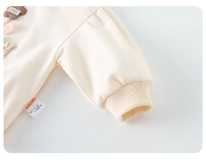 Gros plan sur le poignet côtelé et l'applique florale 3D d'un sweat-shirt pour bébé