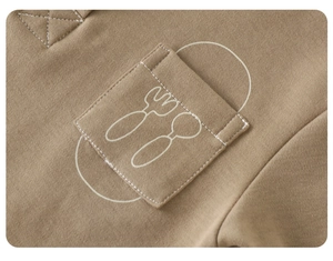 Detail of baby boy autumn brown sweatshirt with spoon and fork cutlery print on small pocket