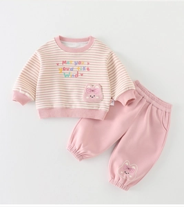 Dettaglio dell'abbigliamento per neonata a righe con ricamo a coniglio e pantaloni rosa