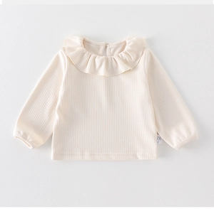 Detailed close-up of the ruffled collar and ribbed fabric texture on baby's long sleeve top