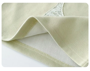 Detail view of mint green knitted cotton fabric with fine stitching and floral lining