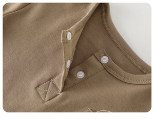 Detail view of cotton Henley neck with three white buttons and precise X-pattern stitching