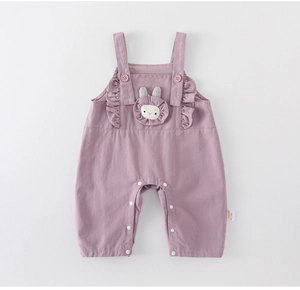 Detail of purple cotton baby overalls with rabbit embroidery and ruffle straps