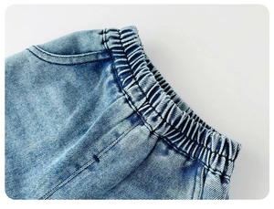 Detail view of baby girl blue wash denim jeans showing elastic waist and fine stitching