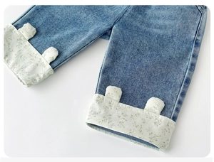 Close-up of baby denim trousers with floral lining and cute bear ear details
