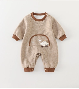 Detail of warm baby romper with mushroom embroidery and metal snap buttons