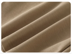 Macro detail of khaki knit cotton fabric showing soft texture and fine stitching on a boy's tee