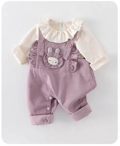 Close-up of baby girl ruffled ribbed top and purple suspender pants with rabbit detail