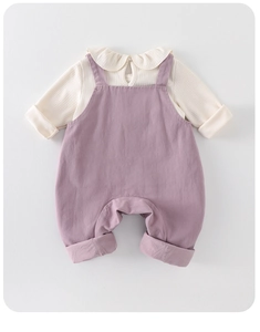 Close-up of baby girl outfit with ruffle collar knit top and lilac suspender pants