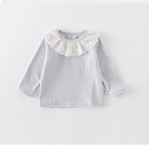 Detail of baby girl cotton shirt with white lace collar and ribbed fabric texture