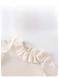 Detail showing baby ribbed knit sweater with ruffle collar and back button closure