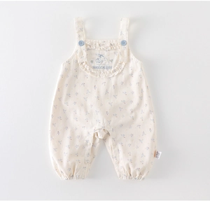 Detailed flat lay of cream floral baby overalls with puppy embroidery and ruffled bib