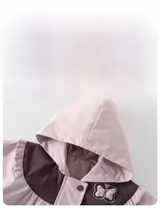 Detail der pink-violetten Windjacke mit Druckknopf, Rüschen und Schmetterlings-Stickerei
