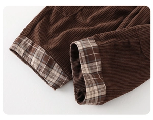Detailed macro view of dark brown corduroy fabric with vintage plaid lining on hem