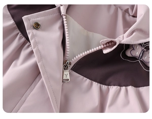 Detail einer Windjacke mit Schmetterlingsstickerei, Reißverschluss und Metalldruckknopf