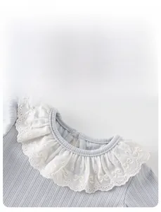 Close-up of baby girl light blue ribbed top with embroidered lace bow collar