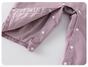 Close-up of snap button closure on baby girl romper for easy diaper changes