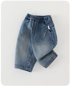 Detailed shot of elastic waistband and blue washed texture on boys denim pants