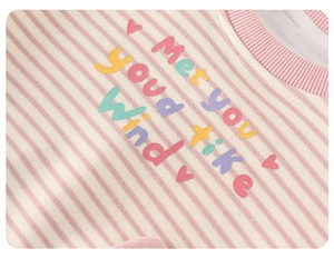 Dettaglio del tessuto a maglia a righe rosa e bianche con ricamo Met You Like Wind