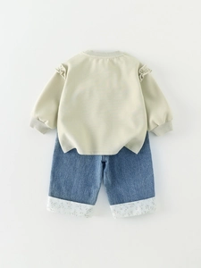 Baby girl fall outfit with green ruffled sweatshirt and floral cuff blue denim jeans