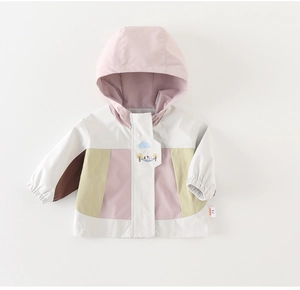 Detalle de chaqueta con capucha para bebé con parches de perro y puños elásticos para viento