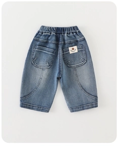 Detail of boys' mid-blue washed denim shorts featuring elastic waistband and smiley patch
