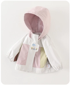 Detalle de chaqueta infantil en bloques de color con bordado de animales y nubes