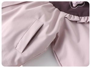 Detail der rosa Mädchenjacke mit lila Akzenten, Rüschennähten und praktischen Seitentaschen