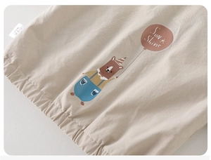 Detailansicht der Kinderjacke mit niedlichem Bärendruck und elastischem Saumdetail