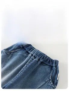 Detail view of boys' denim jeans showing the elastic waistband and side pocket design