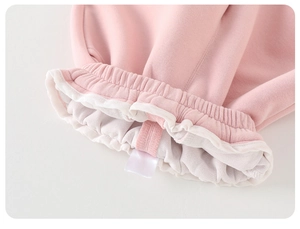 Dettaglio della manica in maglia rosa per neonata con polsini a balze e cuciture fini