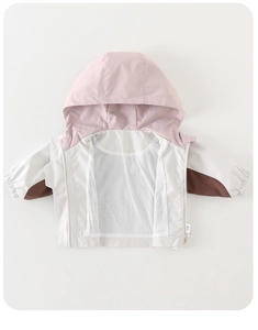 Detalle de chaqueta cortavientos para niño con capucha y diseño de bloques de color