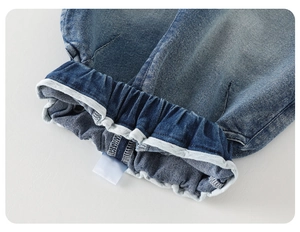 Detailed close-up of elastic waistband on dark blue denim pants for boys
