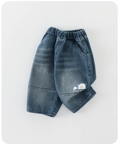 Detail view of boys denim jeans with elastic waist and white Happy Duck cartoon print
