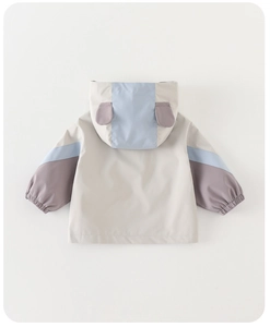 Detail view of children's windbreaker with cute animal ear hood and geometric patchwork