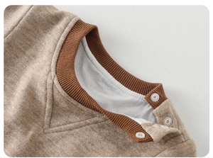 Close-up of baby romper neckline with contrast ribbing and shoulder snap buttons