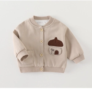Detail of baby waffle knit cardigan with wooden buttons and cute mushroom pocket decoration