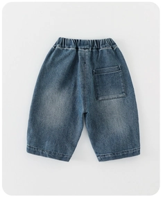 Detailed view of elastic waistband and back pocket stitching on kids' denim shorts