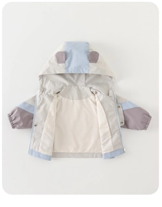Detail of color-block windbreaker for boys featuring cute 3D ears on the hood and zip