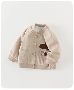 Detail of baby waffle knit jacket in cream with mushroom patch and wooden buttons