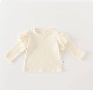 Detailed view of cream-white ribbed baby shirt with ruffled shoulders and size 73 label