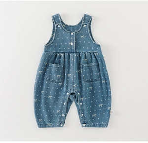 Detail of baby denim overalls with white polka dots, bow patterns and snap buttons