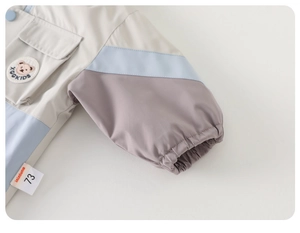 Close-up of kids windbreaker featuring bear embroidery and elastic cuffs on sleeves