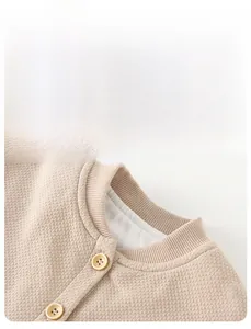 Detail of baby knitted cardigan with ribbed collar and soft waffle texture fabric
