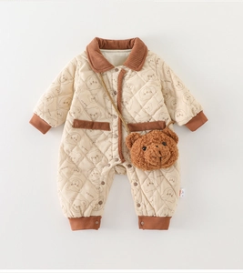 Detail of baby quilted romper with bear patterns and brown corduroy trim finish