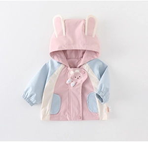 Detalle de cortavientos para niñas con orejas de conejo y un parche decorativo de osito
