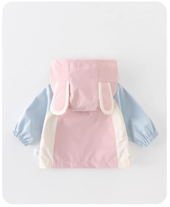 Detalle de chaqueta cortavientos infantil con orejas de conejo 3D y bloques de color