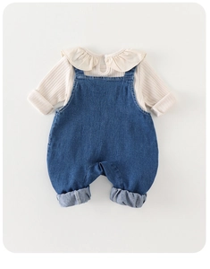 Detail von Baby-Mädchen Rüschen-Body und blauem Denim-Latzhosen-Set, zweiteilig