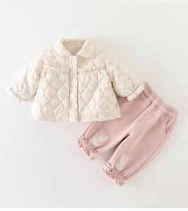 Close-up of baby winter quilted set featuring floral ruffles and cute bunny patch detail