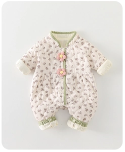 Détail d'une grenouillère matelassée pour bébé avec fleurs 3D et bordures vertes